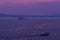 Ship sails on a background of purple sunset sky on the waves of Lake Baikal from Olkhon