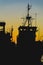 Ship at sunset in dock, loading, unloading. Silhouette, port landscape. Bright sunset