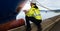 Ship supervisor engineer inspector stands at the dockside in a port. Wearing safety helmet and yellow vest. Cargo shipping