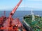 Ship to ship offshore oil transfer operation in action on Etna vulcano background