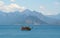 A ship with tourists sails along the Mediterranean Sea against the backdrop of mountains