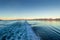 Ship wake at dawn, lighting rugged mountains across ocean channel. Alaska, USA.