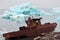 Ship wreck on Arctic coast with icebergs on background