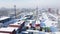 Shipping container and cargo crane at storage yard at winter time aerial view