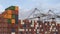 Shipping containers stacked dockside with gantry cranes overhead.