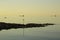 Ships at anchor at the mouth of Belfast Lough as the sun sets over the entrance to Groomsport Village Harbour in Northern Ireland