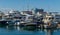 Ships, yachts and boats on blue surface of Black Sea by pier of Commercial seaport of resort city Sochi.