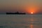 Shipwrecked. Beautiful sunrise at sea. The silhouette of an abandoned wreck in the sea