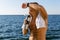 shirtless adult man with towel on shoulders drinking water and wiping sweat after workout