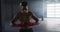 Shirtless african american man preparing hand wraps for boxing in an empty urban building