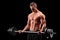 Shirtless athlete exercising with a barbell