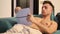 Shirtless athletic young man reading book on sofa