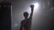 Shirtless boxer cheering about victory, winner raising hand in gloves, smoke and bright illumination