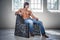 Shirtless fitness male model in a jeans sits on a chair.
