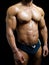 Shirtless male bodybuilder in trunks, really muscular body