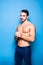 Shirtless man with beard on blue background