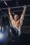 Shirtless man doing exercises on horizontal bar.