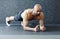 Shirtless Man Holding Plank on Grey