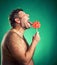 Shirtless man licking candy