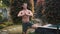Shirtless man with muscular body doing yoga exercises, greenery on background