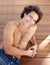 Shirtless man, portrait and happpy guy in jeans laying down on wood floor with happy and sexy smile. Attractive, healthy