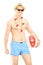 Shirtless man in swimming shorts, holding a beach ball