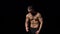 Shirtless muscular man dancing happy on black background, locked down real time video