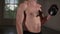 Shirtless muscular man doing workout with dumbbells and sweat on his body. Close up of man`s torso during workout
