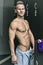 Shirtless muscular young male athlete in gym dressing room