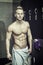 Shirtless muscular young male athlete in gym dressing room