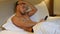 Shirtless muscular young man in bed typing on cell phone