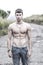 Shirtless muscular young man walking on rural road