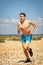 Shirtless teenage boy running on a beach