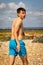 Shirtless teenage boy running on a beach