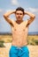 Shirtless teenage boy running on a beach