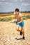 Shirtless teenage boy running on a beach