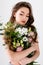 Shirtless woman holding bouquet of chrysanthemums