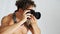 Shirtless young man with professional photo camera