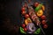 Shish kebab BBQ meat with onions and tomatoes. On a black background. Top view Rustic style