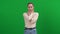 Shivering young slim woman standing at green screen looking at camera. portrait of sad Caucasian ill lady posing at