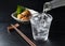 Shochu and nibbles set against a black wood grain background
