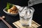 Shochu and nibbles set against a black wood grain background