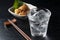 Shochu and nibbles set against a black wood grain background