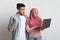 Shock Content. Surprised muslim couple holding laptop, emotionally reacting to internet news