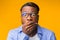 Shocked African American Guy Covering Mouth With Hand, Yellow Background