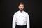 Shocked amazed young bearded male chef cook or baker man in white uniform shirt posing isolated on black wall background