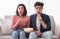 Shocked Asian Couple Watching TV Eating Popcorn Sitting At Home