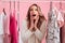 Shocked beautiful lady choosing clothes