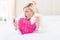 Shocked blonde woman lying on the bed and texting with her mobile phone