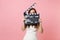 Shocked bride woman in wedding dress hiding covering face with classic black film making clapperboard on pastel